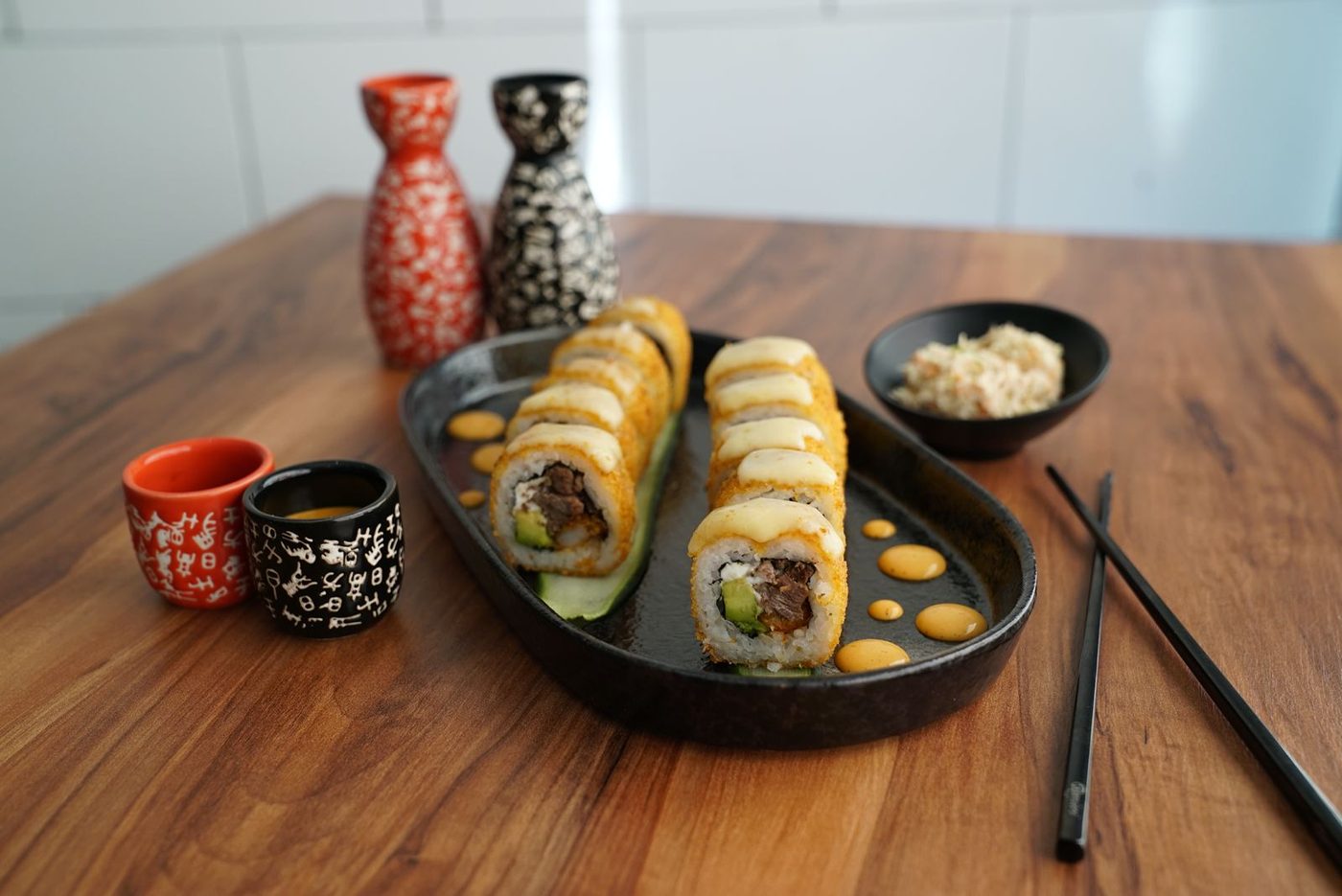Rollos de sushi gratinados con res, aguacate y aderezo de la casa